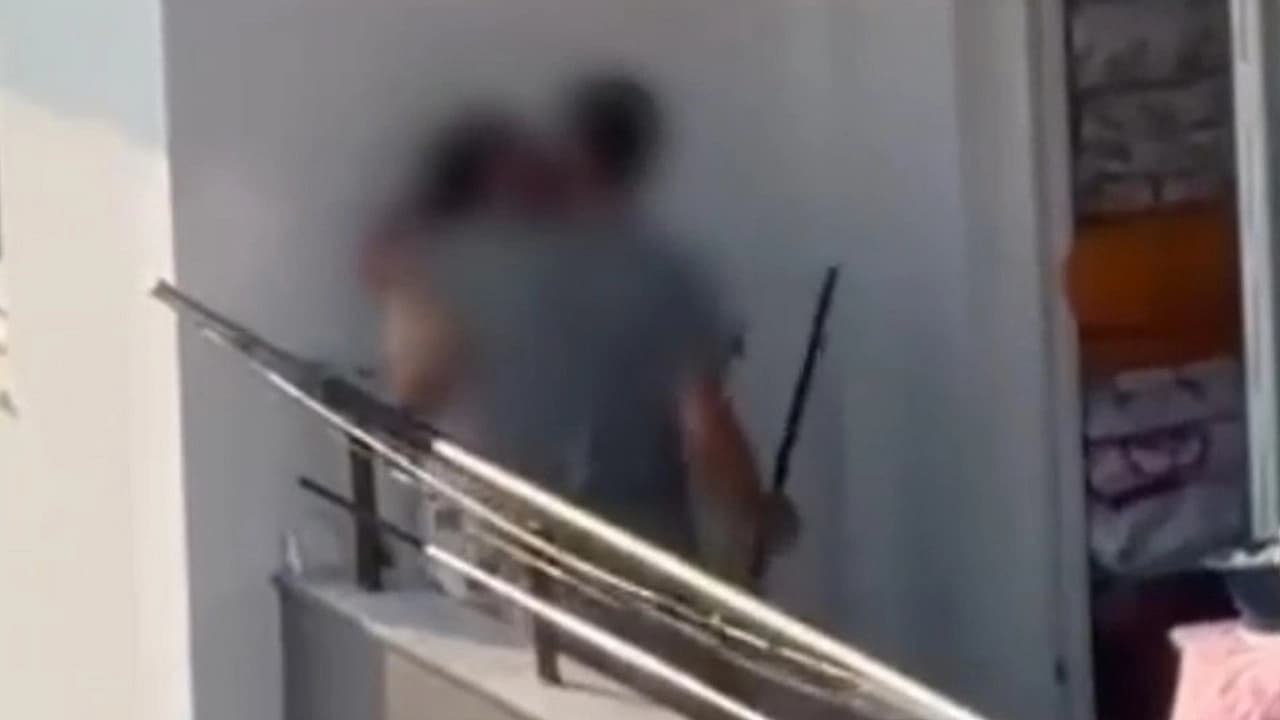 Kadını balkonda sopa ile darp etti